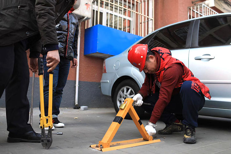 学院南路32号院，执法队在拆除地锁。北太平庄街道辖区内老旧社区20多个，占街道社区总数的54%。老旧小区大部分建于上世纪七八十年代，小区停车位等配套设施缺乏科学规划，随着市民机动车保有量的飞速增长，停车难问题日益凸显。