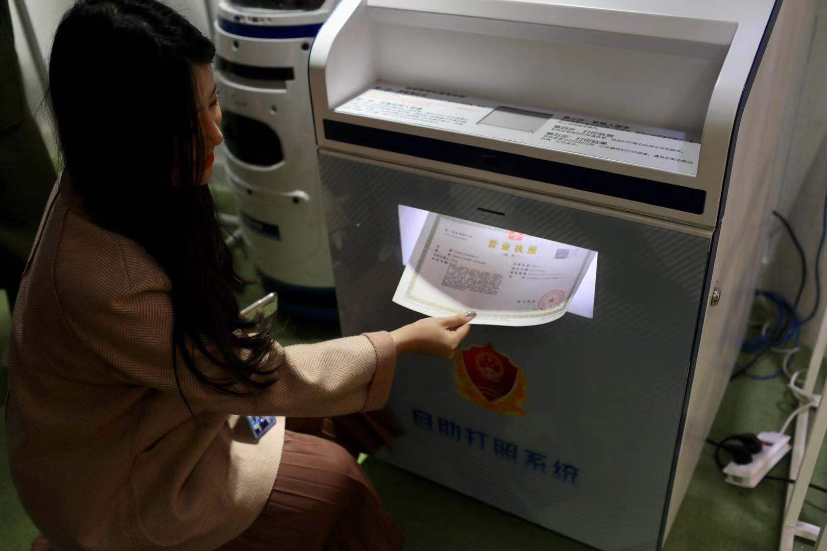 吴女士在打印海淀区首份新版营业执照。