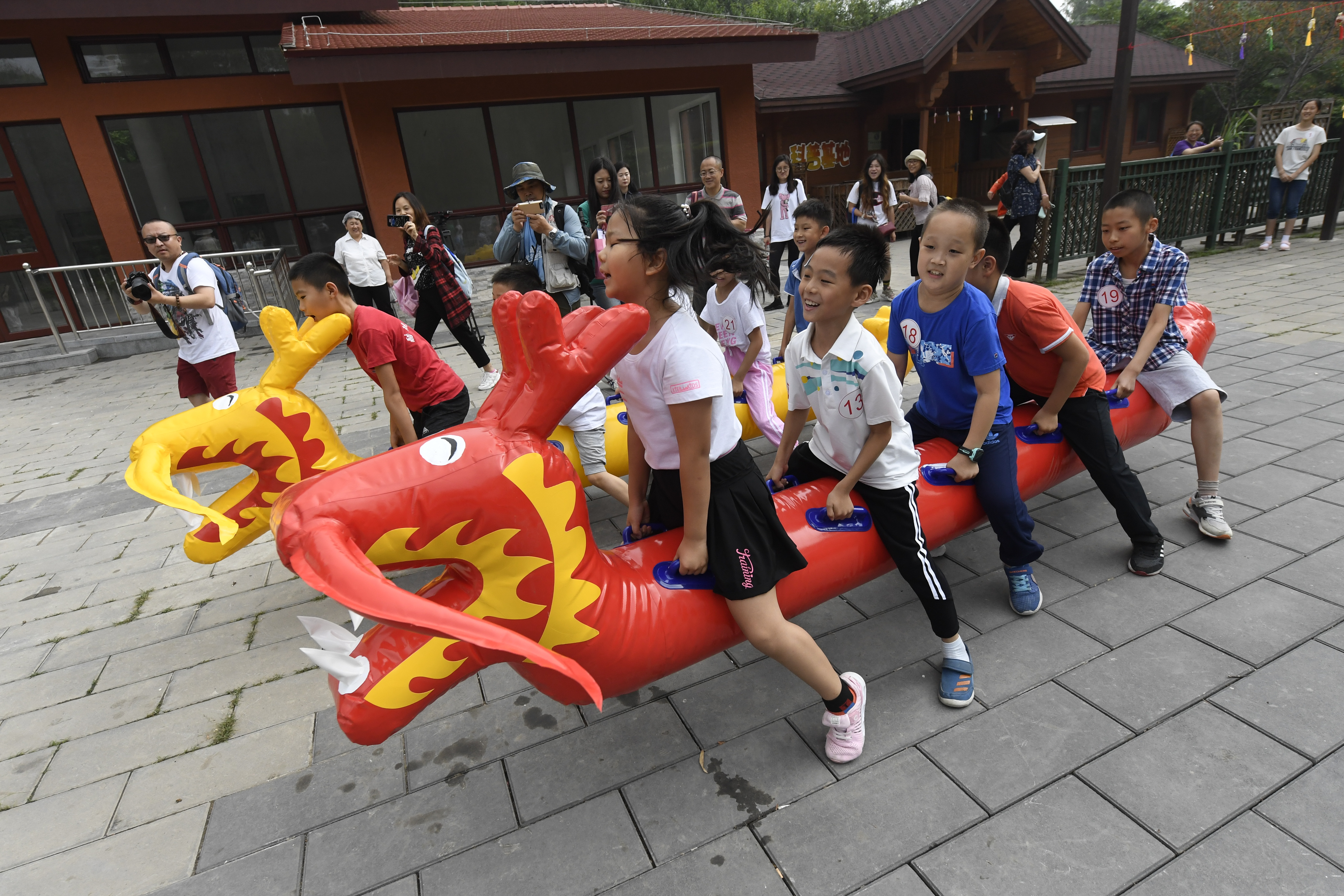 玉渊潭公园科普木屋广场,"旱地龙舟"比赛吸引了小朋友参与.