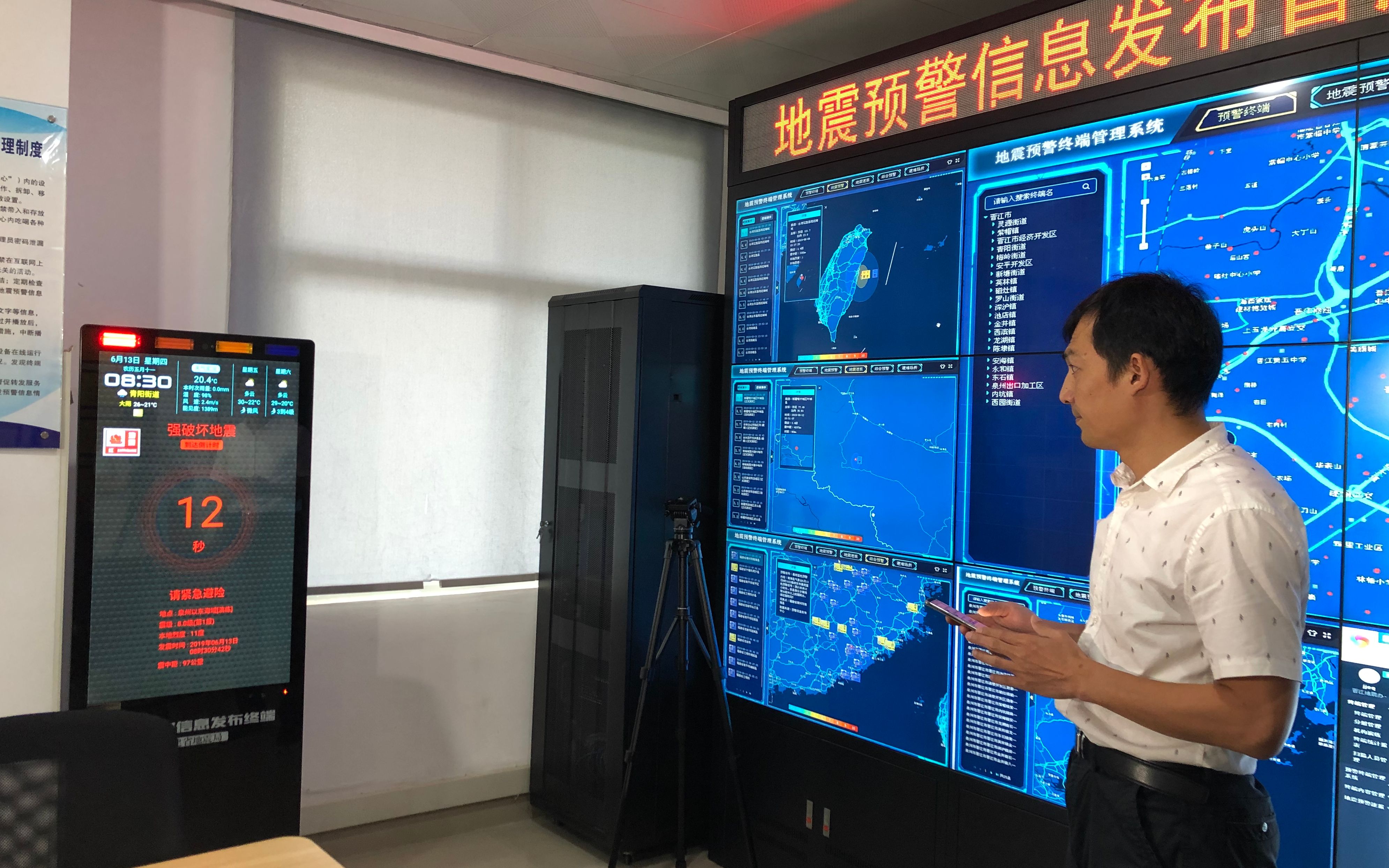 福建省晋江市地震预警信息发布分中心，技术人员模拟演示终端机发出预警信息的情景。新京报记者 周依 摄