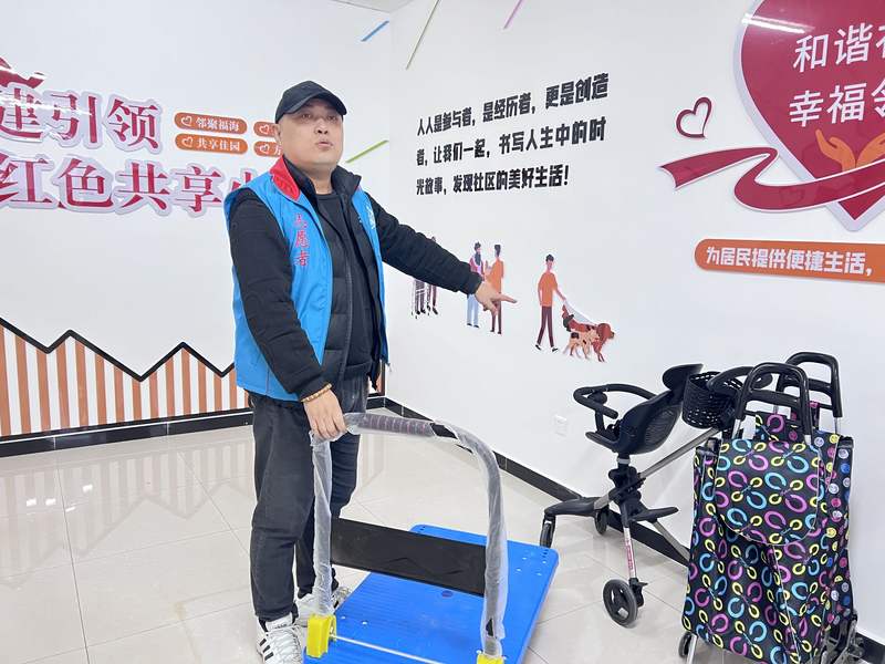 共享小屋志愿者高润在整理小屋里的共享手拉车、共享婴儿车。新京报记者 陈璐 摄