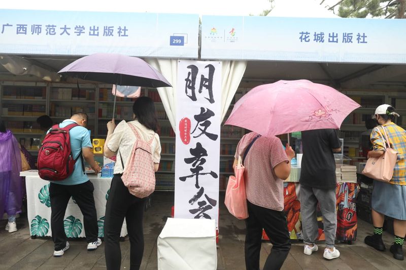 9月8日，地坛公园，不少市民在雨中逛书市。 新京报记者 浦峰 摄