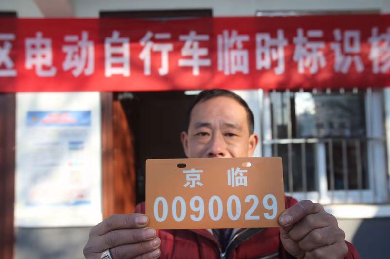 市民民领取到电动车临时标识.摄影 王贵彬