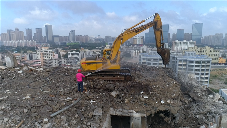 海南海口挖掘机爬上22层高楼作业