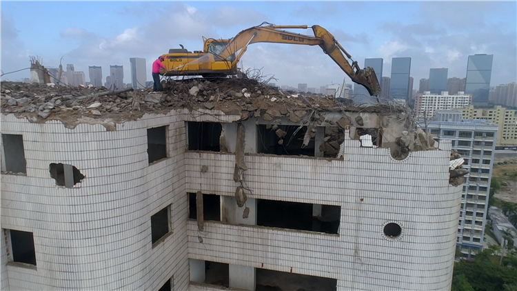 海南海口挖掘机爬上22层高楼作业