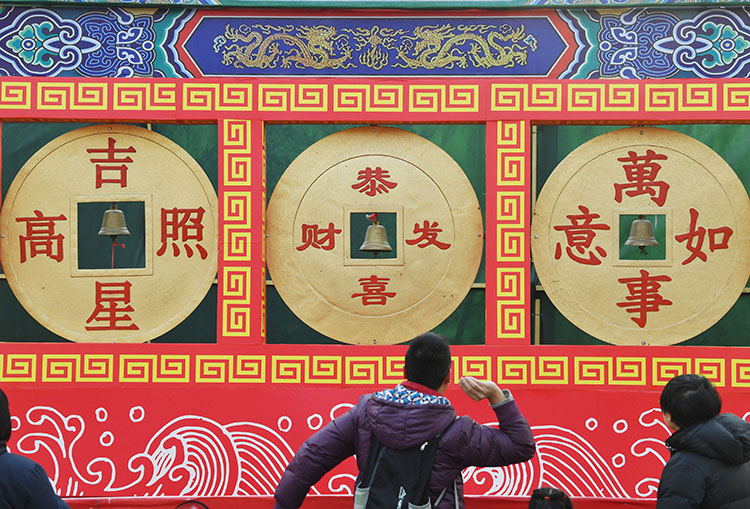 游客掷铜钱,讨"好彩头.