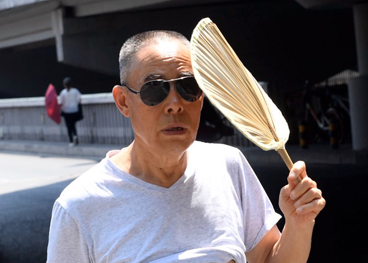 广渠门桥,一位大爷手持蒲扇抵挡刺眼的阳光.