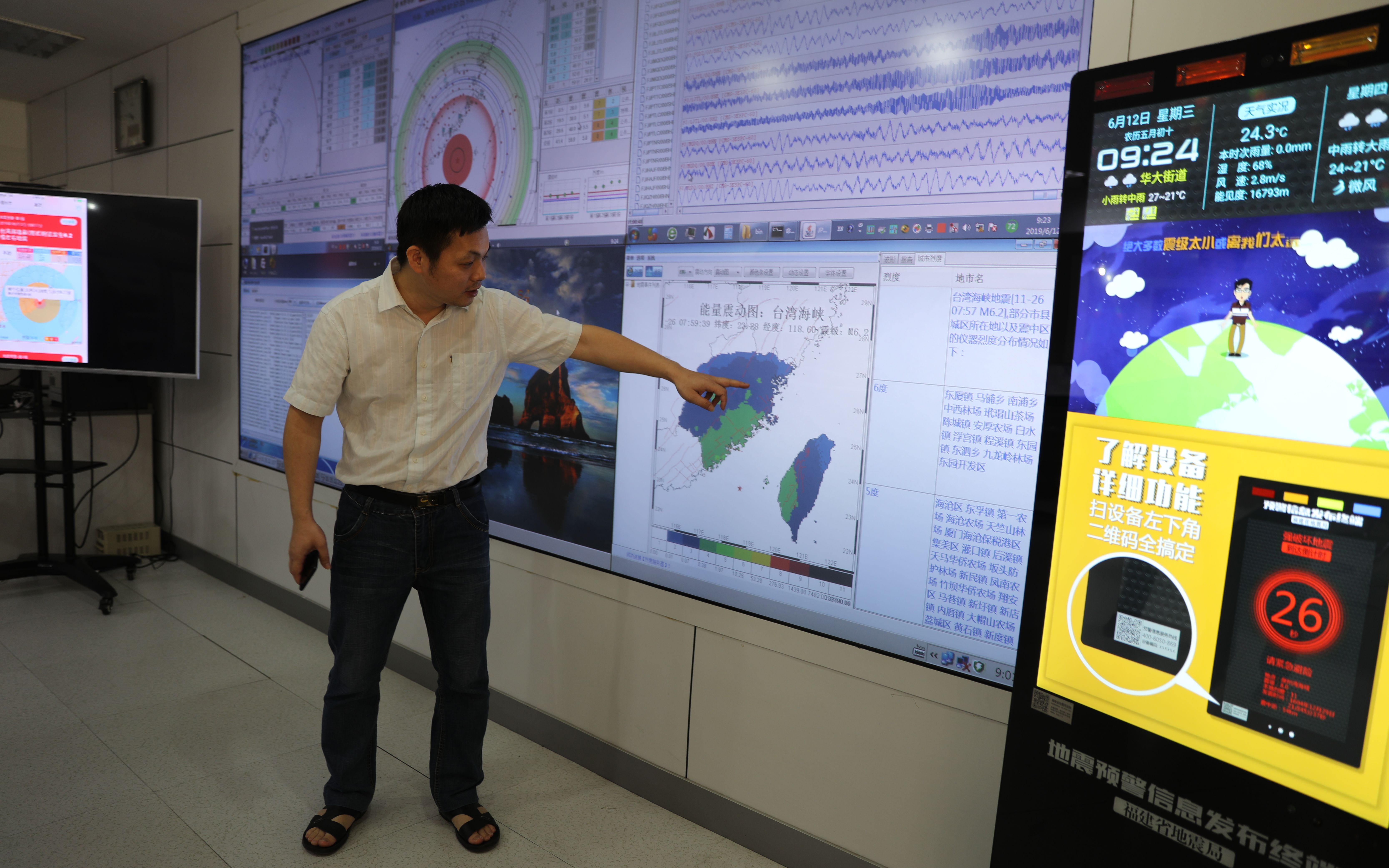 福建省地震局监测中心总设计师韦永祥展示地震预警技术系统运行生成的信息。中国地震局供图