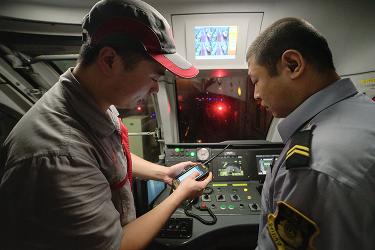 7月20日凌晨,古城地铁车辆段,检修员登车与地铁司机进行交接.