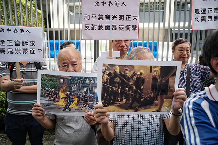 请愿示威中，香港市民展示蒙面示威者图片。