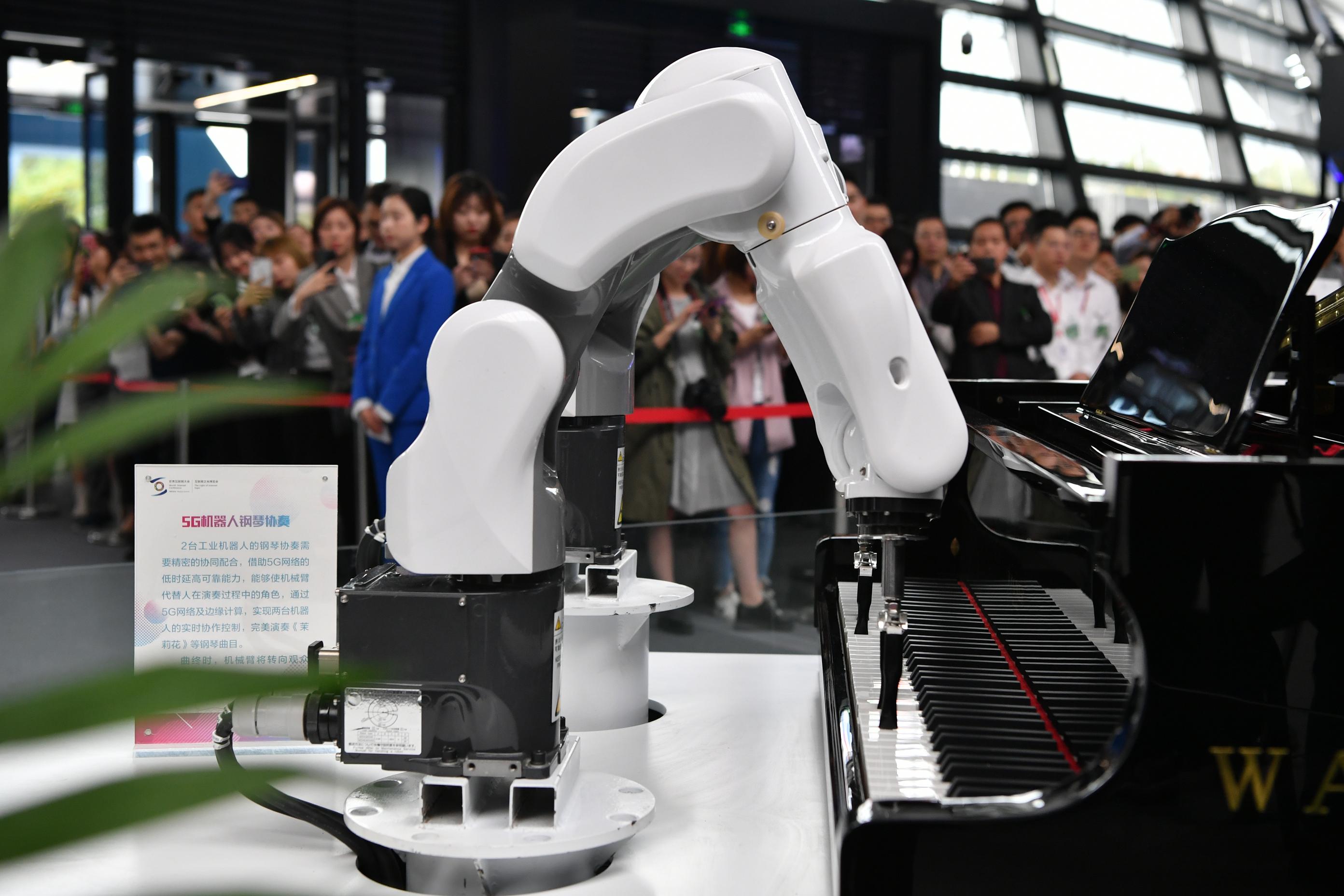 开幕式现场,机器人在用钢琴弹奏《茉莉花》.