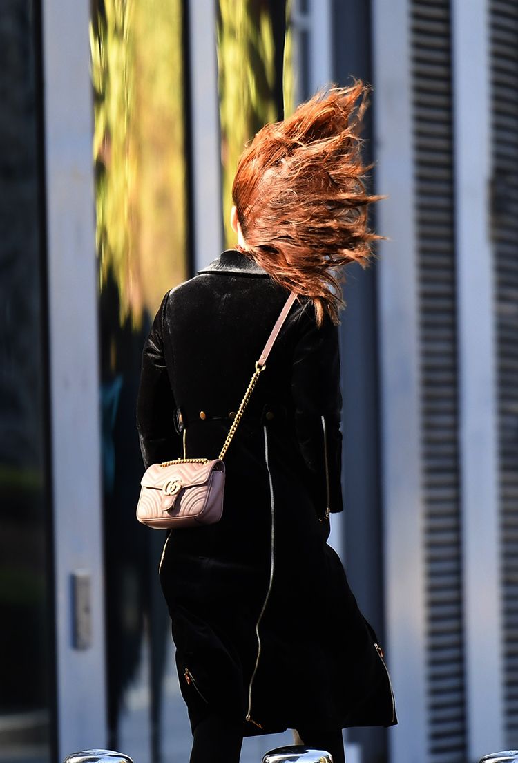 2019年11月13日,北京大风蓝色预警,三里屯soho,路人的头发被大风吹起.