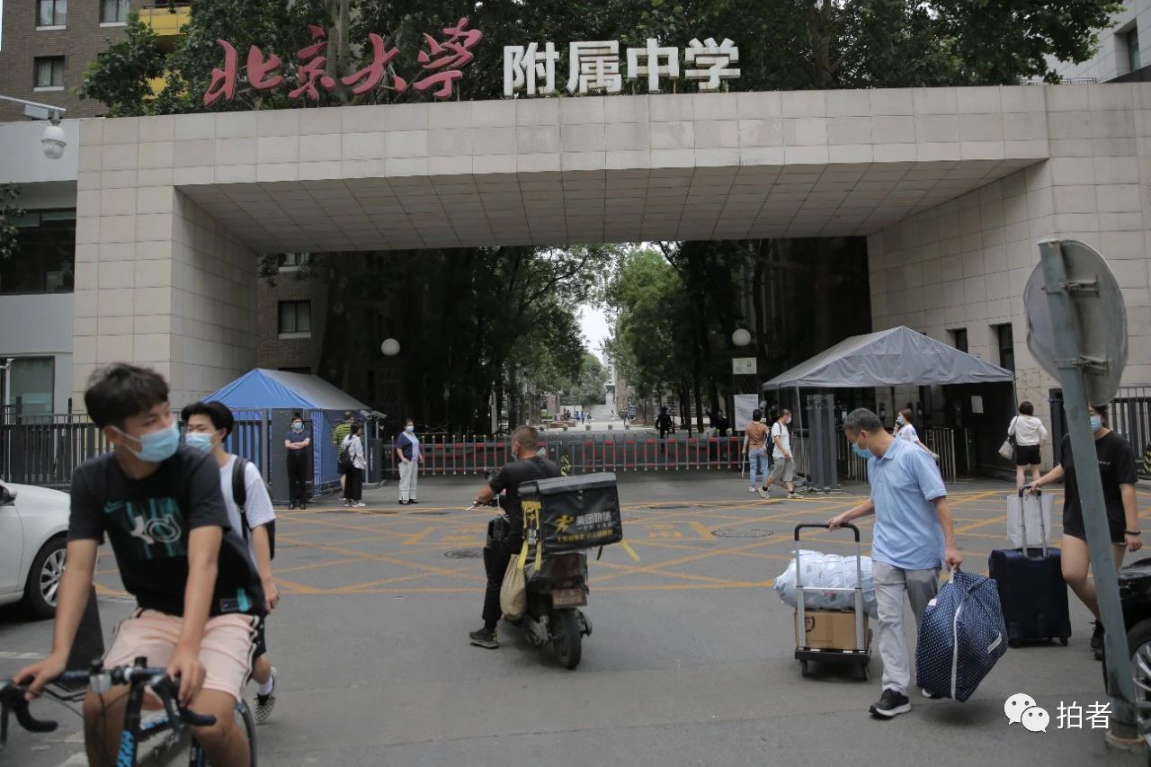 6月17日,北大附中门口,家长拉着孩子的学习物品离开.