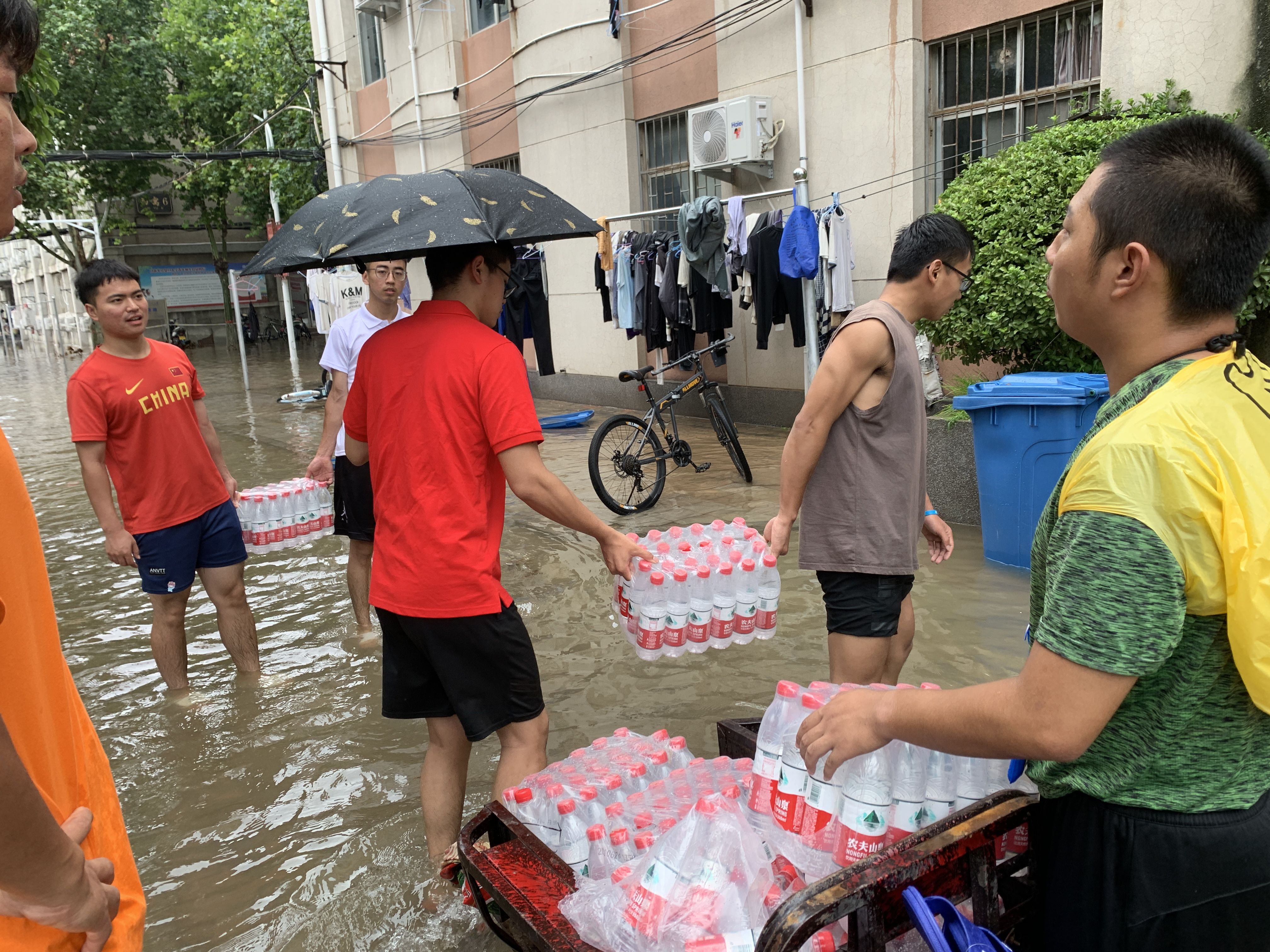 自制沙袋挡雨蹚水送物资河南师大学生齐力抗洪抢险