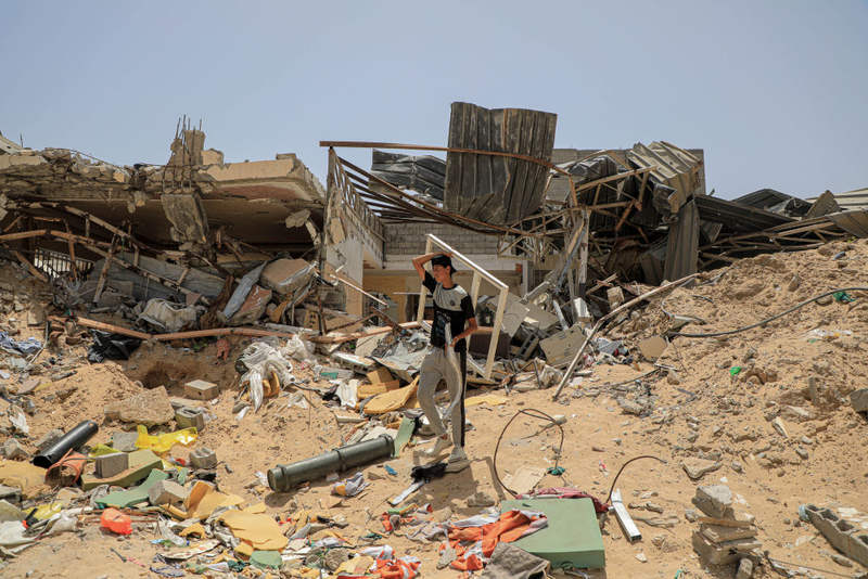 5月21日,在加沙地带南部城市汗尤尼斯,巴勒斯坦人在废墟中捡拾物品。新华社发(里泽克·阿卜杜勒贾瓦德摄) 5月21日,在加沙地带南部城市汗尤尼斯,巴勒斯坦人在废墟中捡拾物品。新华社发(里泽克·阿卜杜勒贾瓦德摄)