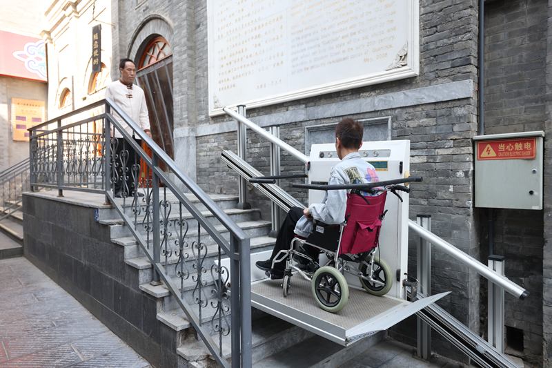 餐厅门前升降平台，工作人员正在演示升降平台使用。新京报记者 王贵彬 摄